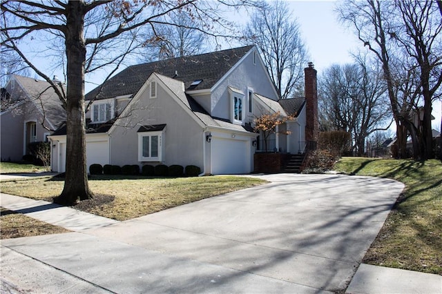 view of side of home with a garage, a yard, driveway, and stucco siding