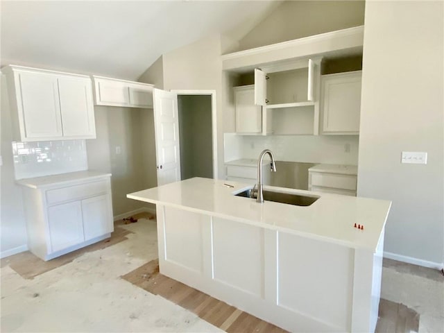 1103 Noah Ln, Kearney, MO 64060 - kitchen featuring a center island with sink, lofted ceiling, white cabinets, light wood-style flooring, and decorative backsplash
