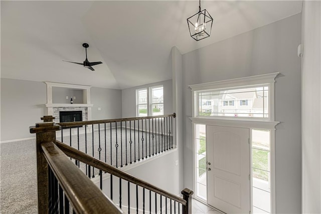 1103 Noah Ln, Kearney, MO 64060 - carpeted foyer entrance with vaulted ceiling, a ceiling fan, and a glass covered fireplace