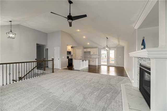 1103 Noah Ln, Kearney, MO 64060 - unfurnished living room featuring dark carpet, lofted ceiling, ceiling fan, and a fireplace