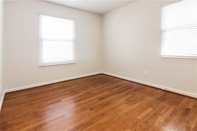 empty room with plenty of natural light and wood-type flooring