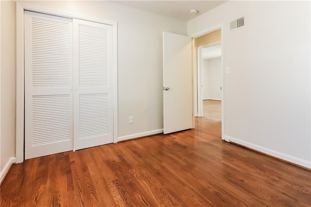 unfurnished bedroom with hardwood / wood-style floors and a closet