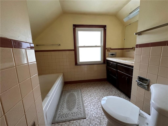 bathroom featuring lofted ceiling, vanity, tile walls, and a washtub