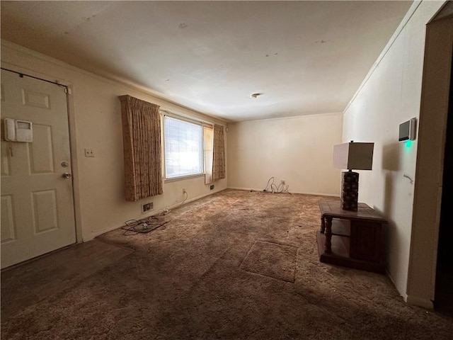 unfurnished living room featuring ornamental molding and carpet