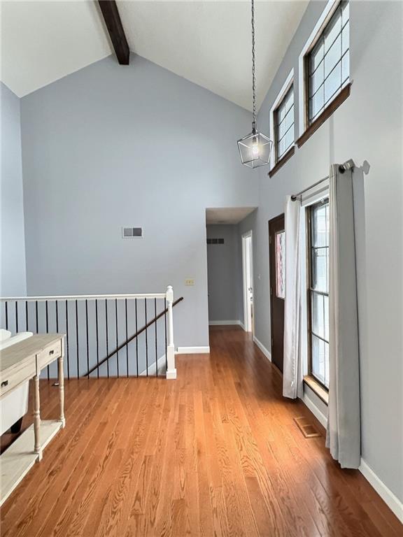 foyer with high vaulted ceiling, beamed ceiling, and light wood-type flooring