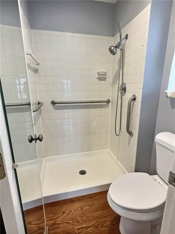 bathroom featuring tiled shower and toilet