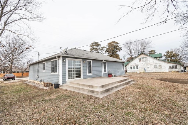 back of property with a yard and a patio