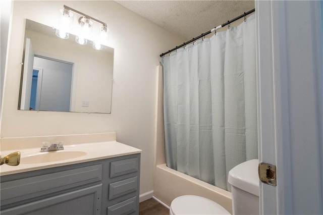 full bathroom featuring vanity, shower / tub combo with curtain, a textured ceiling, and toilet