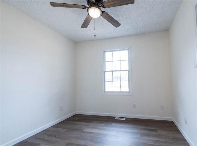 empty room featuring ceiling fan, dark hardwood / wood-style floors, and a textured ceiling