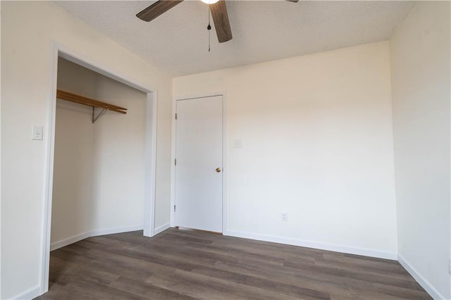 unfurnished bedroom with ceiling fan, dark hardwood / wood-style floors, a textured ceiling, and a closet