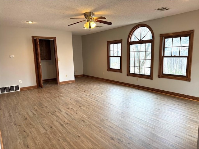 unfurnished room featuring ceiling fan, a textured ceiling, and light wood-type flooring