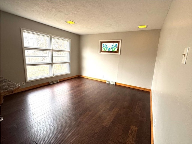 unfurnished room featuring dark hardwood / wood-style floors and a textured ceiling