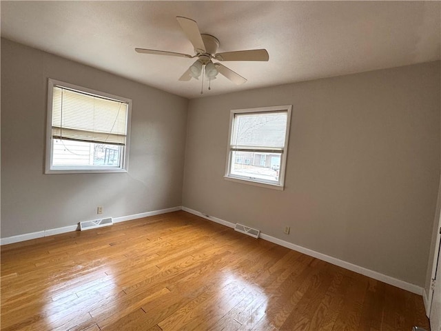 unfurnished room with ceiling fan, light hardwood / wood-style floors, and a wealth of natural light