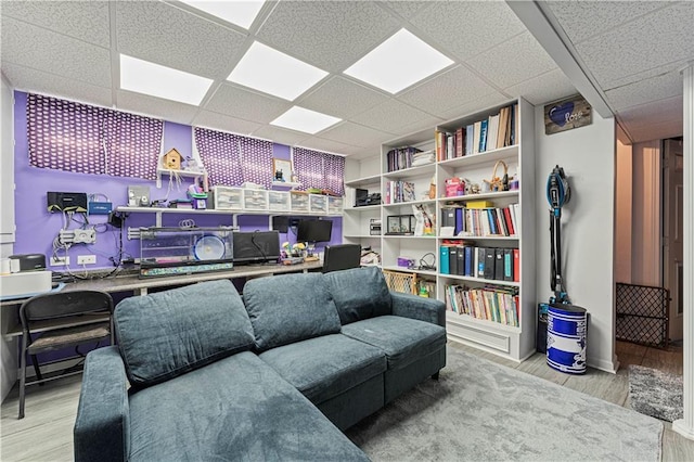 living room featuring a drop ceiling and wood finished floors