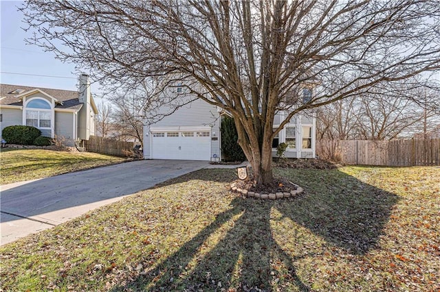 view of front of home featuring a front lawn, fence, a garage, and driveway