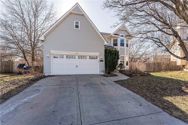 view of front of home with an attached garage, fence, and driveway