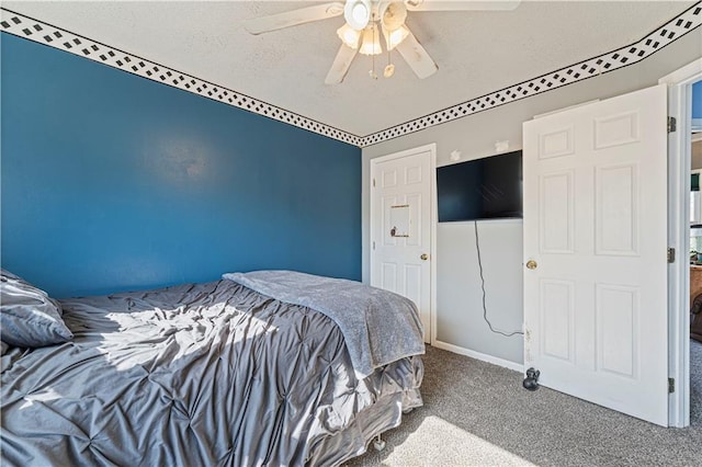 bedroom featuring a textured ceiling, a ceiling fan, and carpet