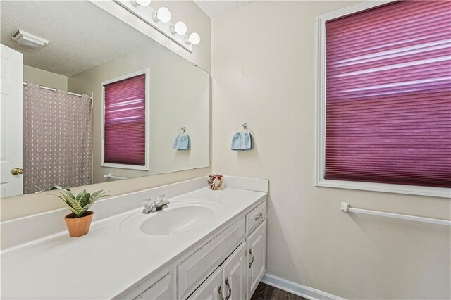 bathroom featuring vanity, a shower with curtain, baseboards, and a textured ceiling