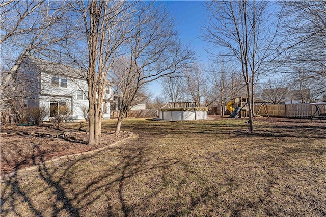 view of yard with a fenced in pool, a playground, and fence