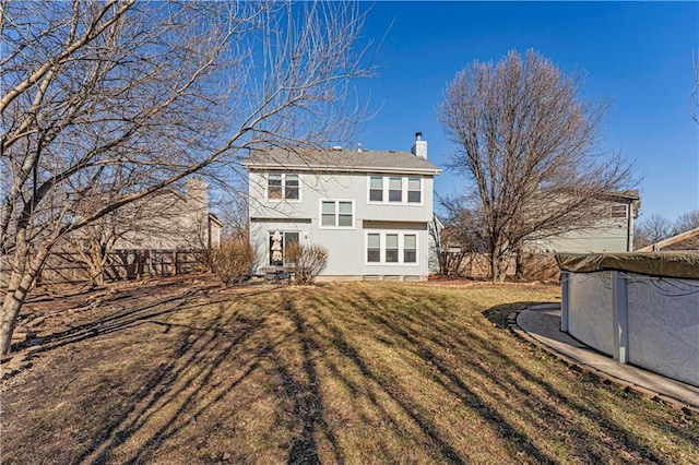 back of property with a yard and a chimney