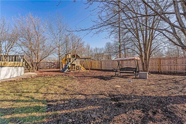 view of yard with a fenced backyard and a playground