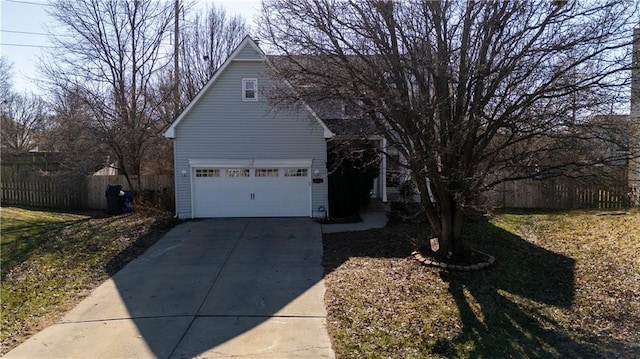 view of property exterior with concrete driveway and fence