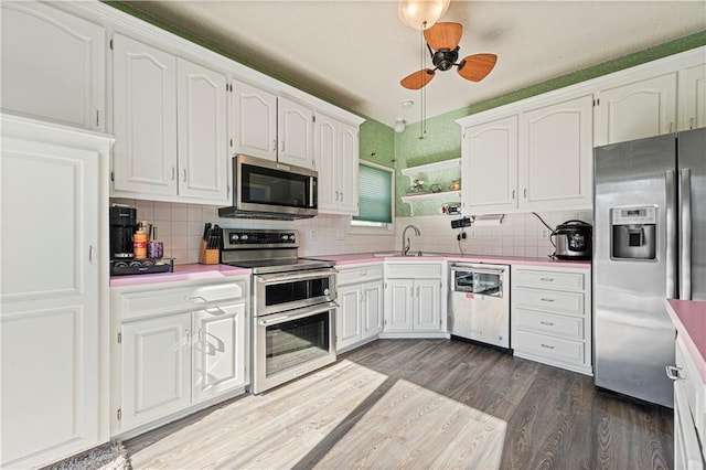 kitchen featuring white cabinetry, stainless steel appliances, light countertops, and wood finished floors