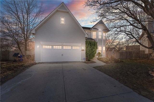 property exterior at dusk featuring concrete driveway and fence