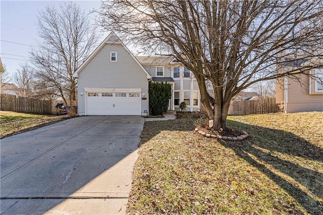 traditional-style house with an attached garage, fence, and driveway