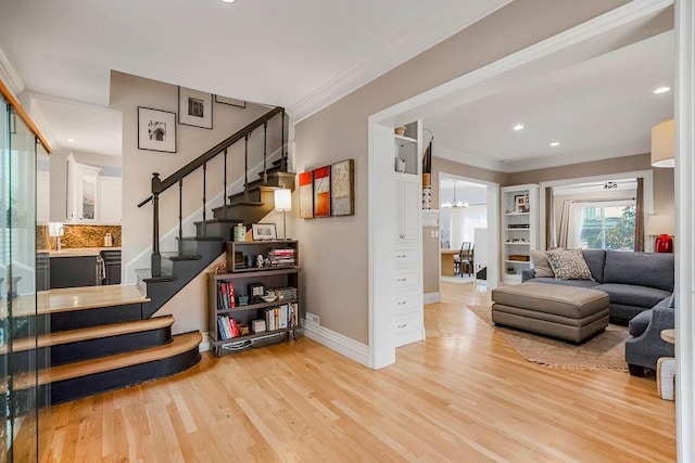 interior space with ornamental molding, a notable chandelier, and light hardwood / wood-style flooring