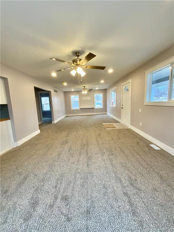 unfurnished living room with ceiling fan and carpet flooring