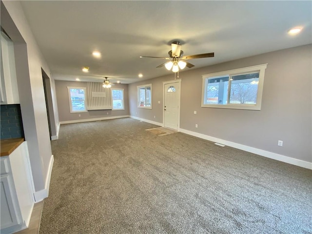 unfurnished living room with ceiling fan and carpet flooring