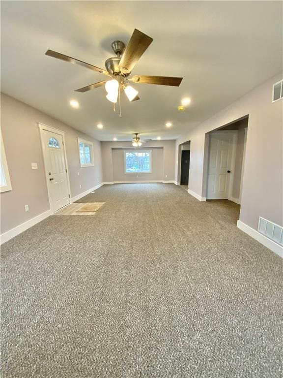 unfurnished living room featuring ceiling fan and carpet flooring