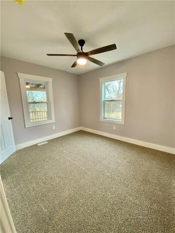 spare room with plenty of natural light, carpet floors, and ceiling fan