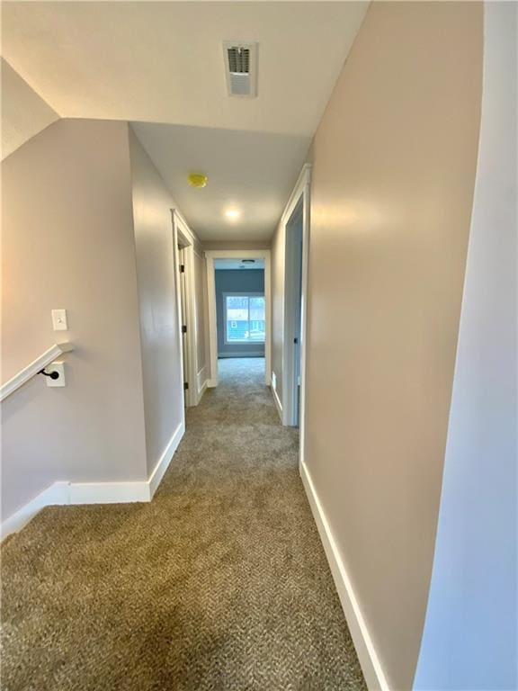 hallway with vaulted ceiling and carpet floors