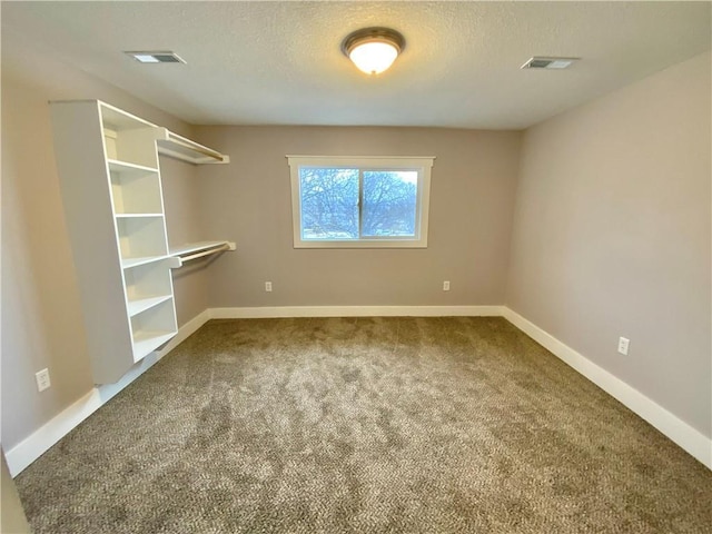 unfurnished room featuring carpet flooring and a textured ceiling