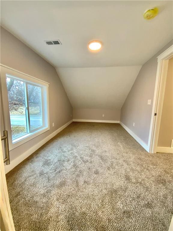 bonus room with vaulted ceiling and carpet