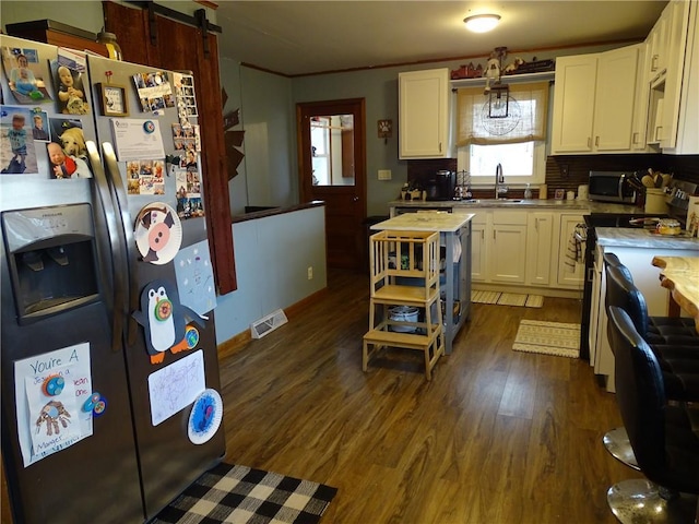 kitchen with sink, dark wood-type flooring, stainless steel appliances, and white cabinets