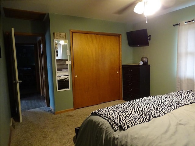 carpeted bedroom with ceiling fan and a closet