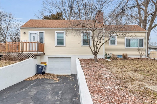 view of front facade featuring a wooden deck and a garage