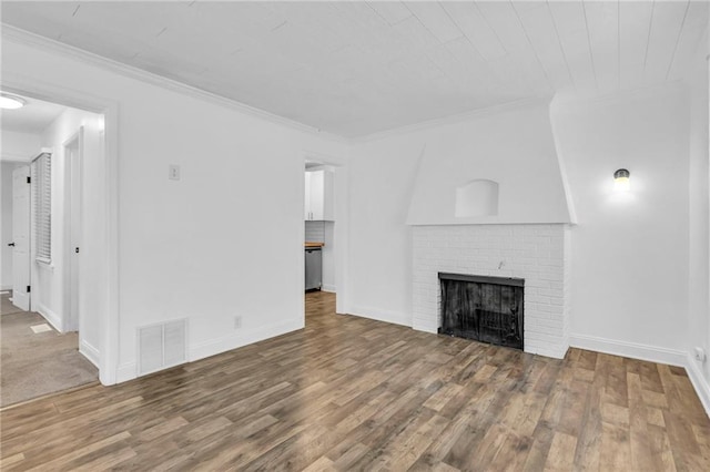 unfurnished living room featuring hardwood / wood-style flooring, ornamental molding, and a fireplace