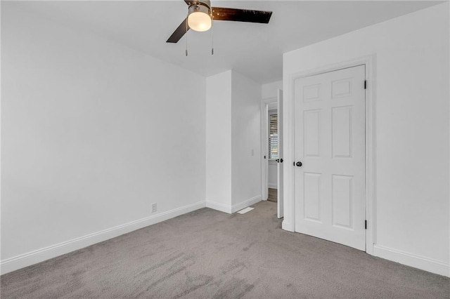 carpeted spare room with ceiling fan