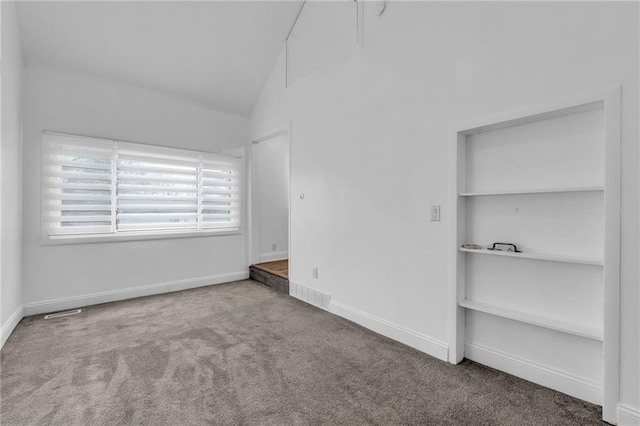 empty room with lofted ceiling and carpet floors