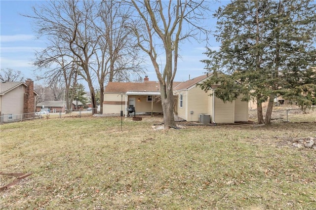 back of property with a yard and central AC unit