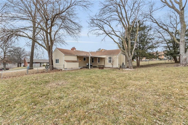 back of house featuring a lawn