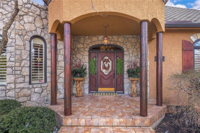 entrance to property with stone siding and stucco siding