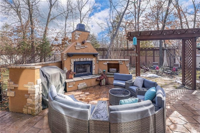 view of patio with fence and an outdoor living space with a fireplace