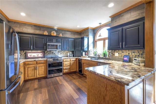 kitchen featuring appliances with stainless steel finishes, dark wood-type flooring, crown molding, and a peninsula