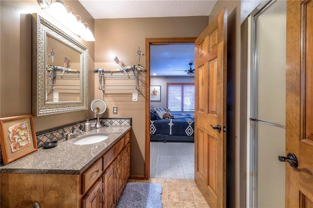 bathroom with a ceiling fan, connected bathroom, and vanity