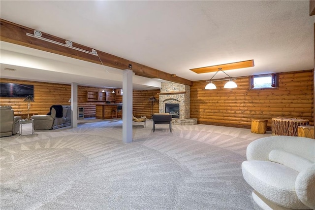 interior space featuring beam ceiling, carpet flooring, a stone fireplace, and rustic walls